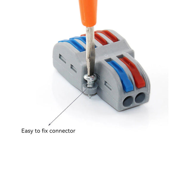 A hand is inserting a metal connector into a gray plastic housing with colored electrical contacts.