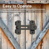 A black stainless steel barn door lock with a classic hook and eye mechanism mounted on weathered wooden planks.