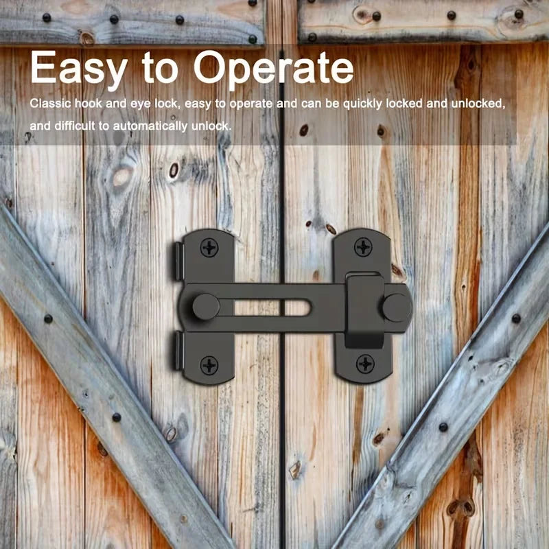 A black stainless steel barn door lock with a classic hook and eye mechanism mounted on weathered wooden planks.