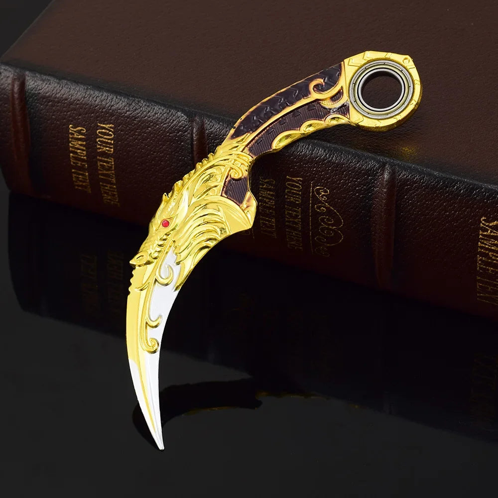 Goldfarbener Drachenklauen-Modellmesser mit dekorativer Griff auf einem dunkelbraunen Buch.