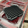A black hexagonal drill bit organizer insert is placed inside a clear plastic tool case.
