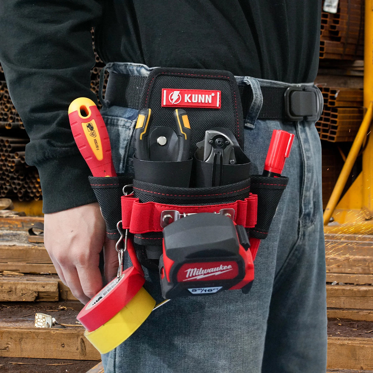 A hand holds a compact utility tool pouch with a red and yellow tool inside, attached to a black belt clip.