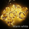 Warmweiße LED-Lichterketten, aufgewickelt und vor dunklem Hintergrund gespannt.
