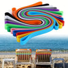 A colorful set of reusable silicone elastic rubber bands spiraled in a vibrant rainbow pattern against a seascape.
