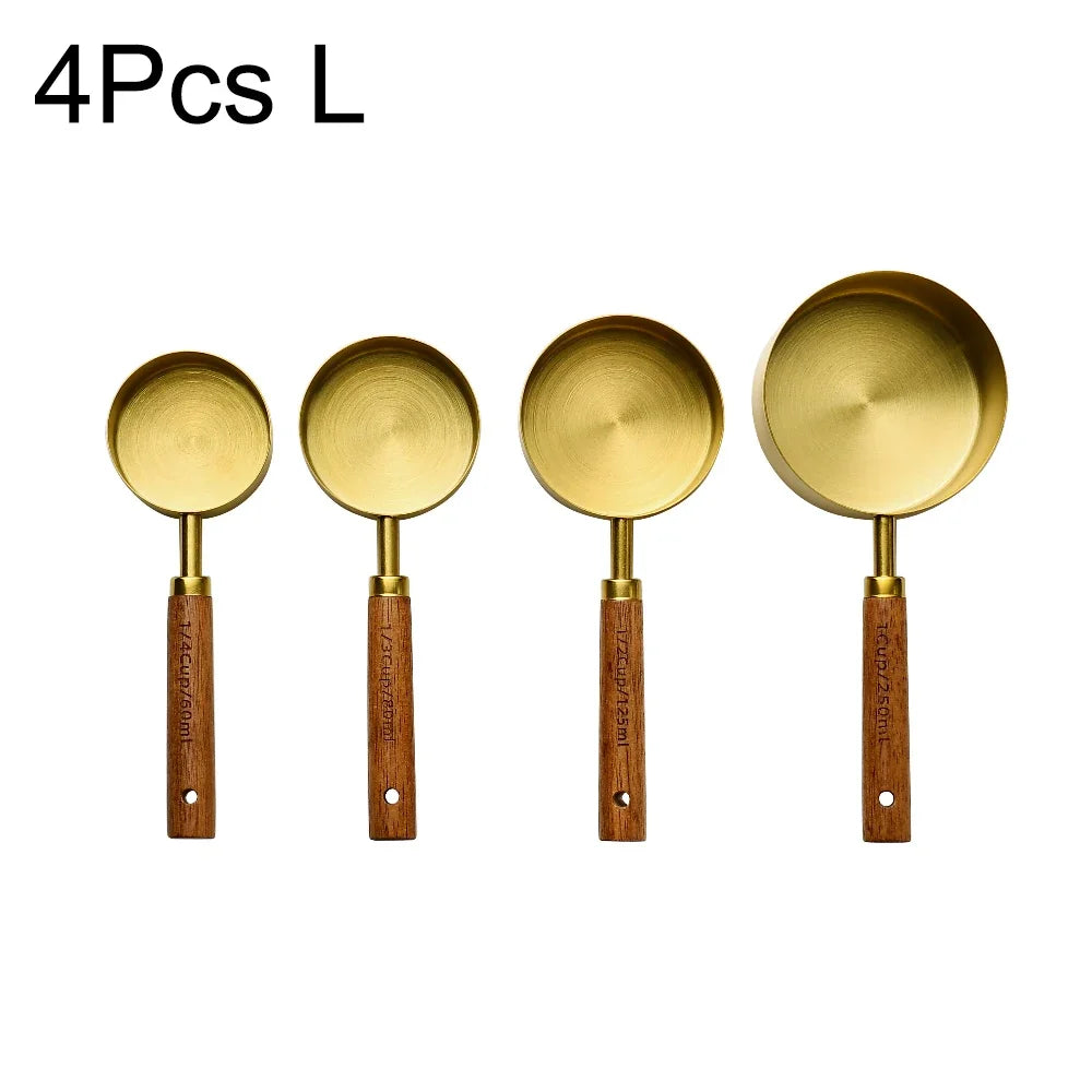 Four stainless steel measuring spoons with wooden handles.