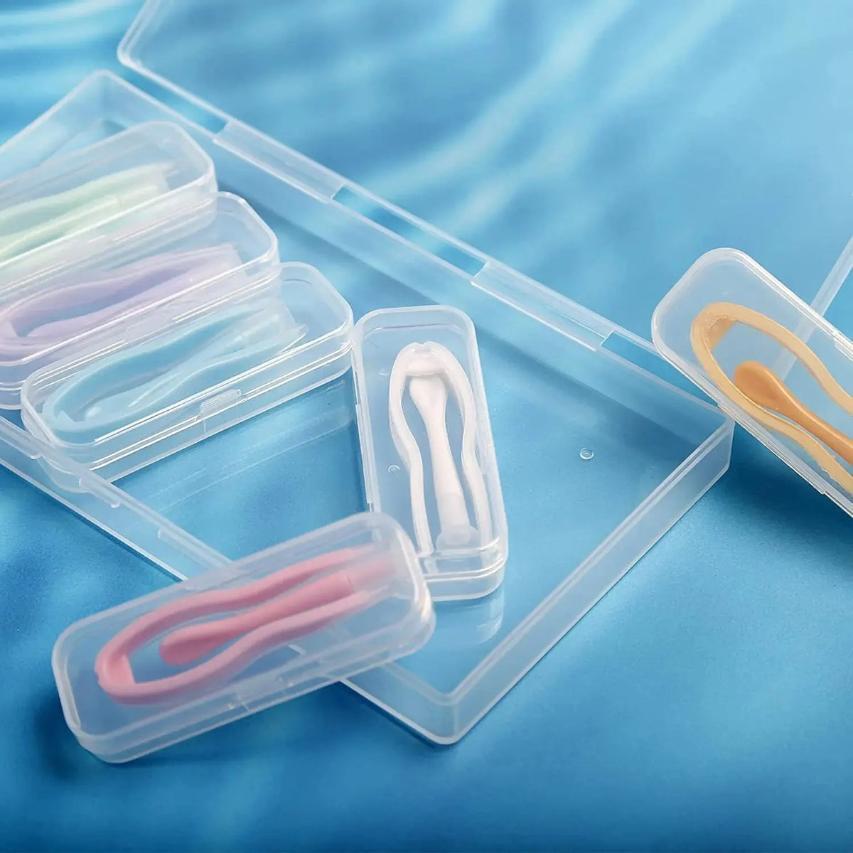 A clear plastic kit containing five pairs of contact lens tools and lenses on a blue background.