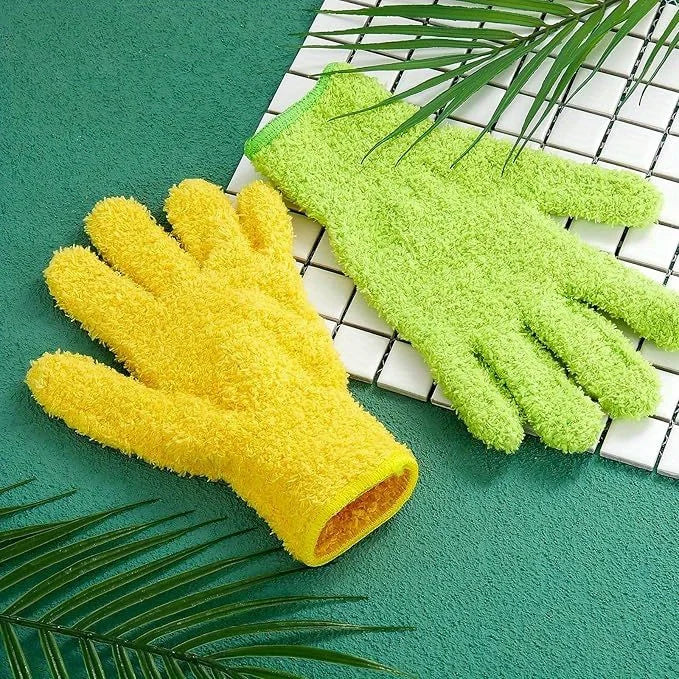 A pair of bright yellow and lime green stretchable microfiber dusting gloves resting on a teal surface next to palm leaves.