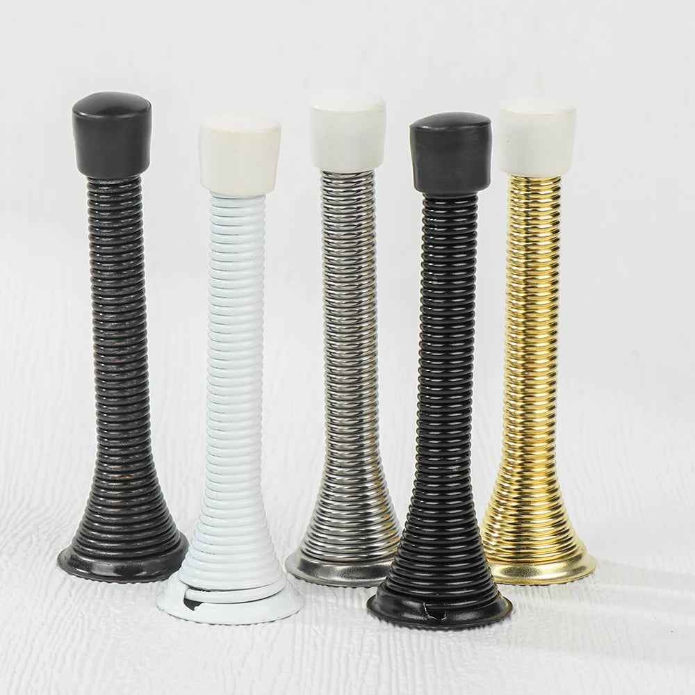 A set of four decorative iron spring door stoppers in black, white, and gold finishes.