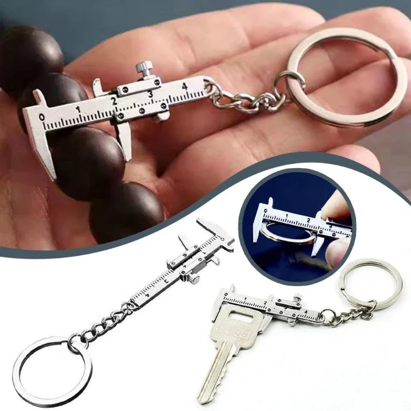 A precision metal jewelry measuring ruler and caliper keychain with a chain and a key attached.