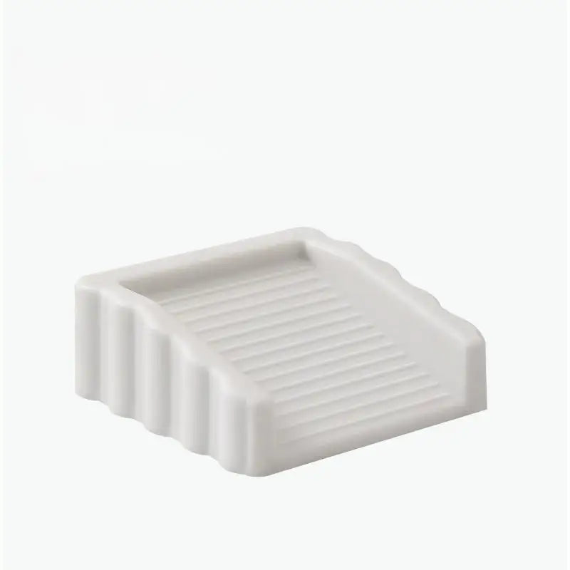 A white reusable TPR door stop wedge with ribbed texture.