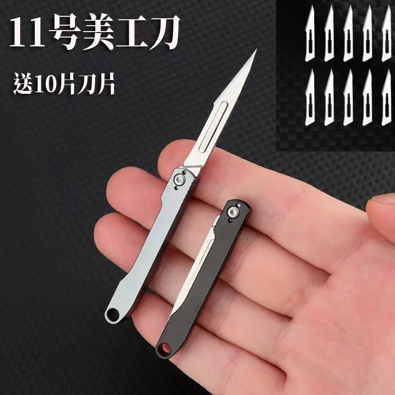 A hand holds a silver mini folding art knife with a black handle, displaying various blade shapes.
