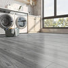 Gray wood grain self-adhesive wall decals installed on a kitchen wall next to a large window.