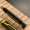 A close-up view of a black and yellow forged geological rock pick hammer resting on a wooden surface.