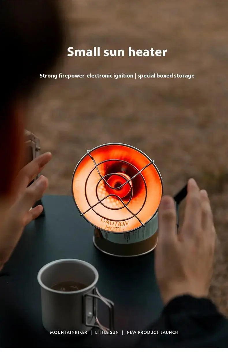 A hand holds a small sun heater with an ignition mechanism and storage box on a dark surface.