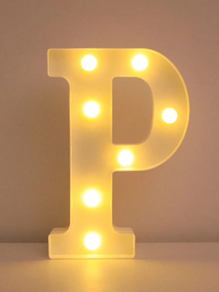 Luz nocturna de una letra P amarilla brillante LED iluminando una superficie blanca.