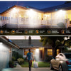 Una luz inundadora LED de sensor de movimiento solar ilumina una exterior residencial por la noche.