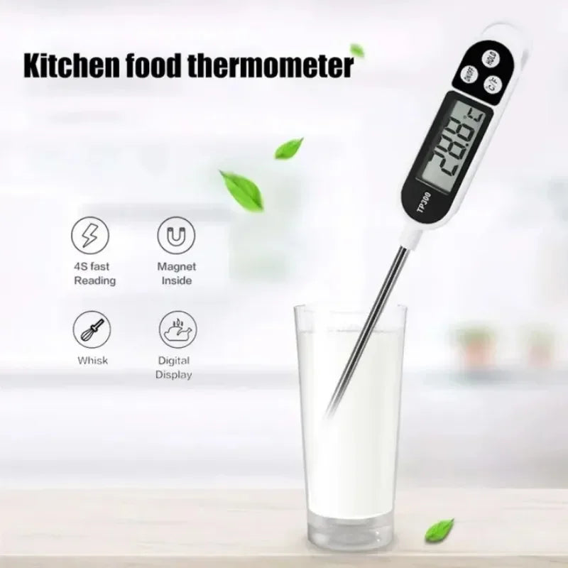Thermomètre de cuisine numérique blanc avec sonde longue à côté d'un verre de liquide.