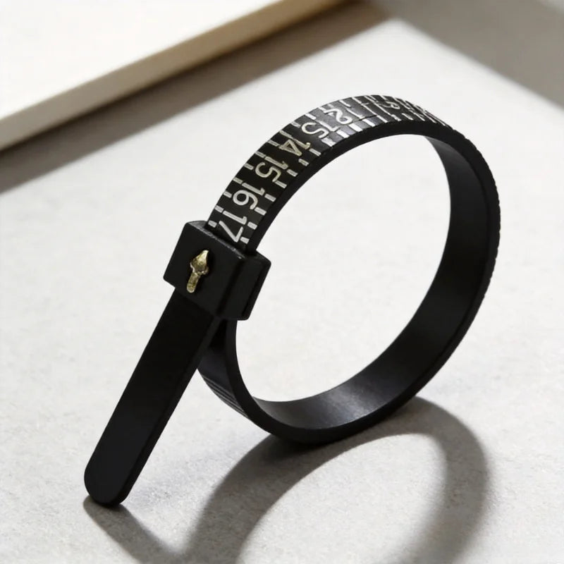 A black finger ring sizer with a numbered scale is shown on a light surface.