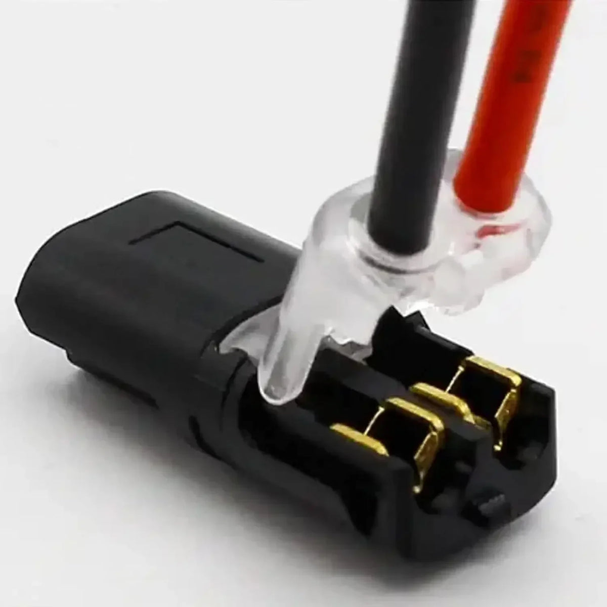 Connecteur électrique noir avec deux broches, boîtier en plastique transparent et fils rouges et noirs.