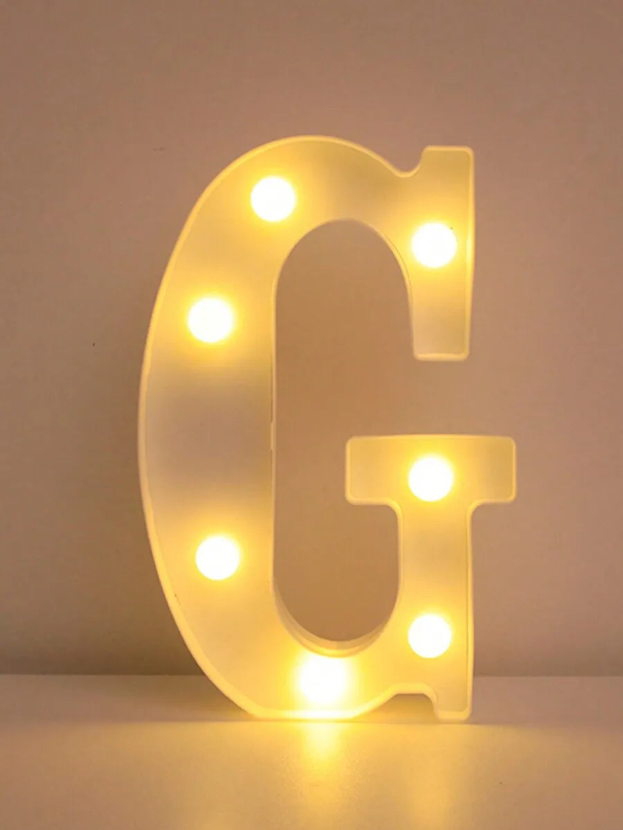 Una letra G brillante hecha de luces LED, utilizada como luz nocturna.