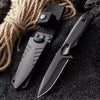 A black stainless steel fixed blade camping knife is shown next to a thick piece of rope on a dark surface.