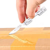 A hand is holding a silver multi-blade folding pocket knife kit above an open cardboard box.