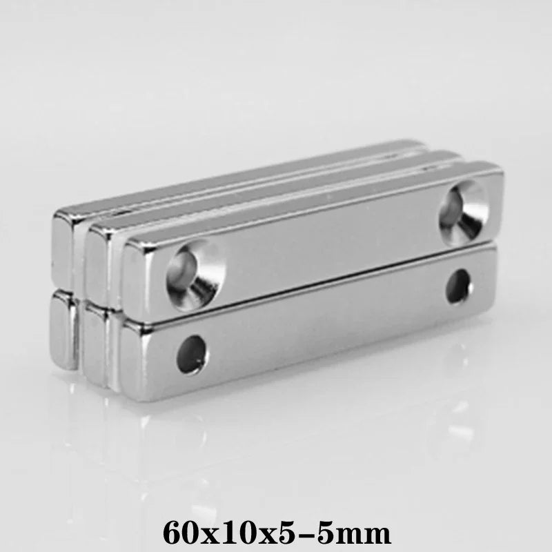 A silver rectangular magnet with mounting holes, measuring 60x10x5-5mm.