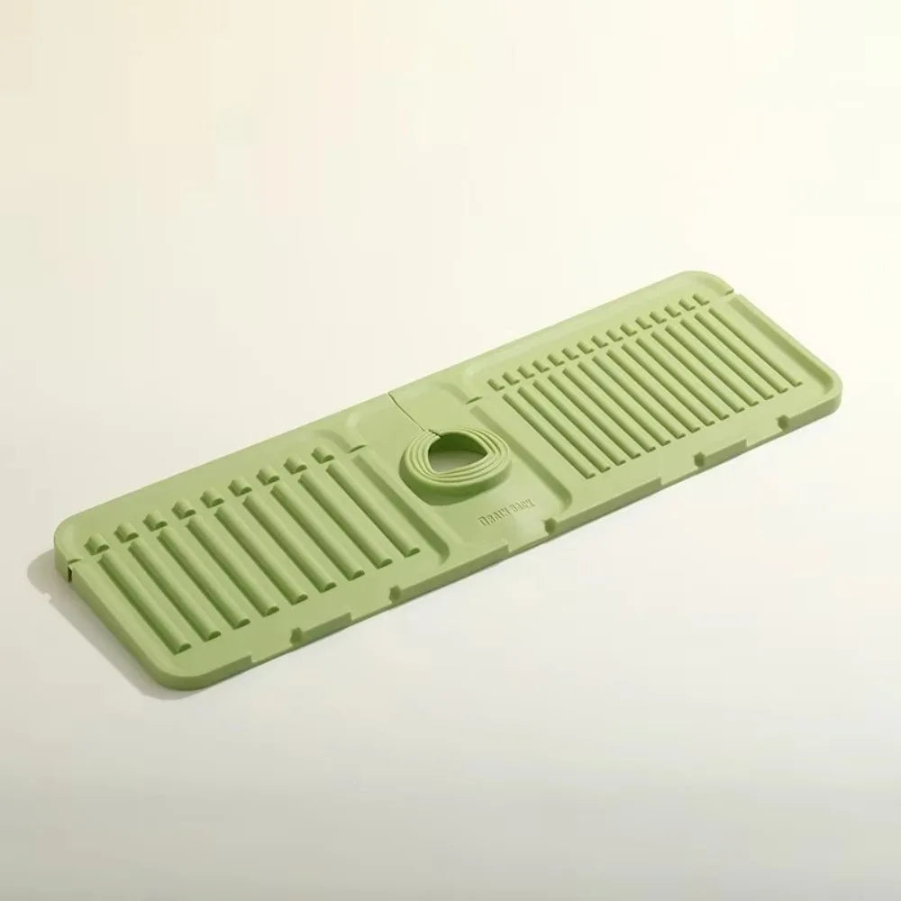 A light green silicone sink drain mat with ribbed texture and a central drain hole.