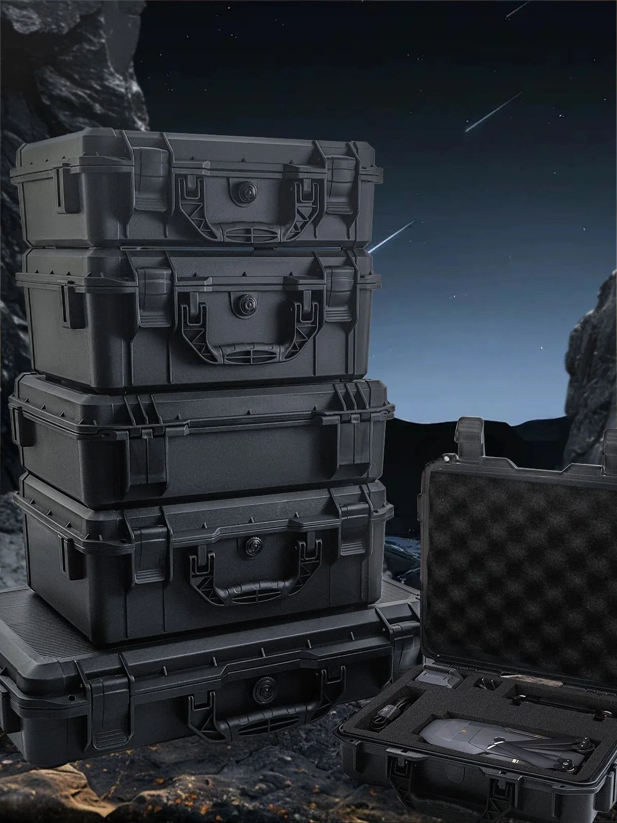 A stack of dark gray universal portable tool boxes and an open box on a rocky surface under a night sky.