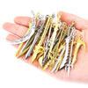 A hand holds a collection of multi-style alloy charms and miniature swords in various silver and gold finishes.
