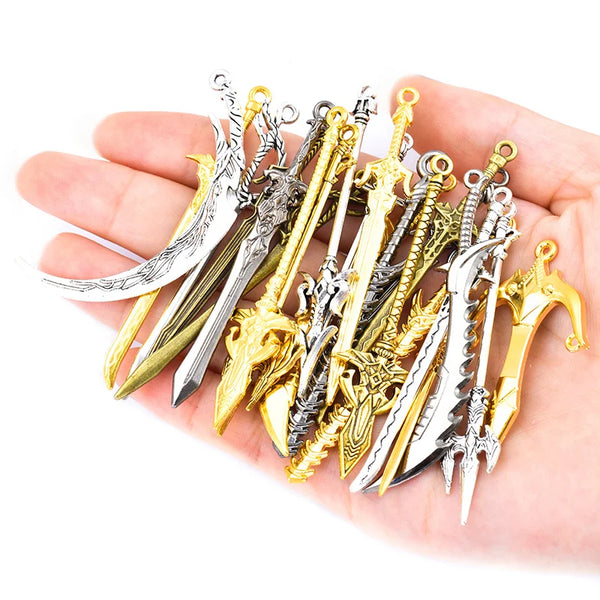 Eine Hand hält eine Sammlung von Multi-Stil-Legierungs-Anhängern und Miniaturschwertern in verschiedenen Silber- und Goldfini