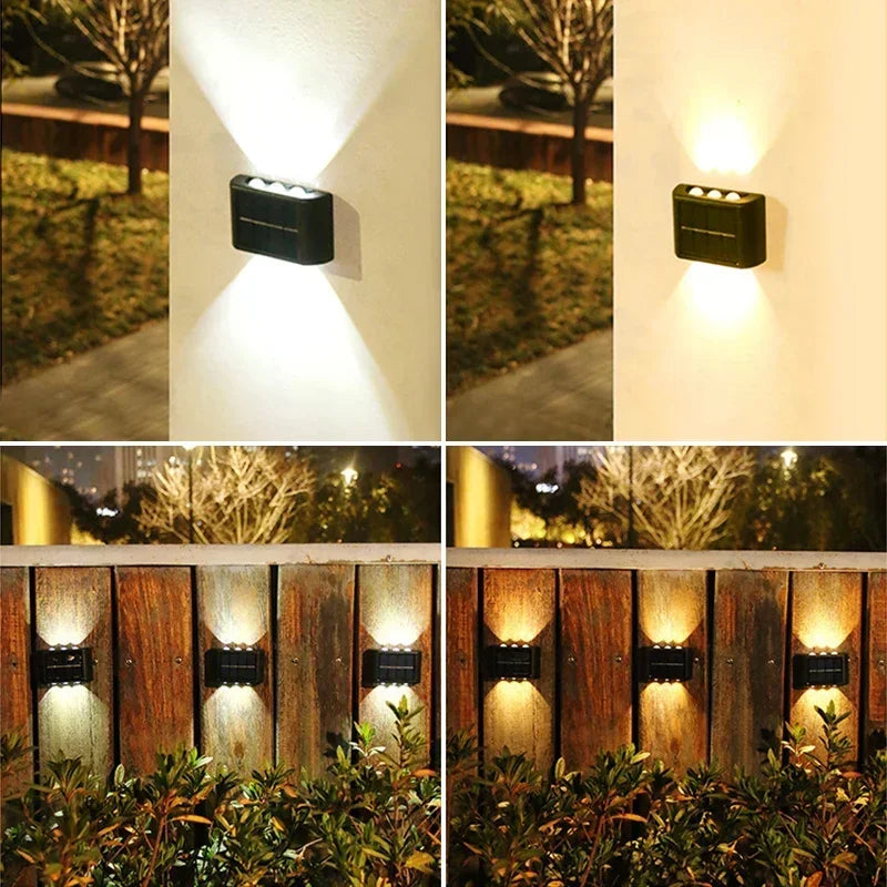 A set of solar wall lights illuminating an outdoor garden area and a wooden fence.