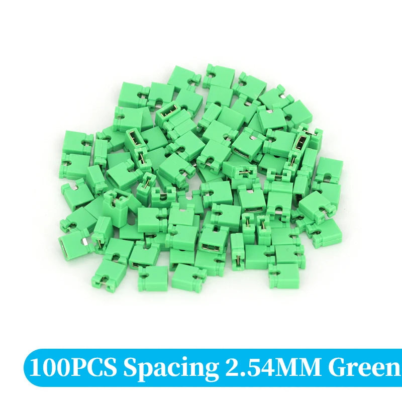 A pile of 100 green spacing jumper cap connectors with 2.54mm pitch.