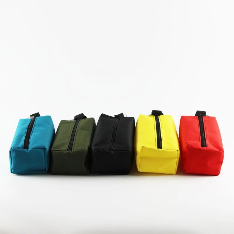 A row of five Oxford cloth hand-held storage bags in teal, olive green, black, yellow, and red.