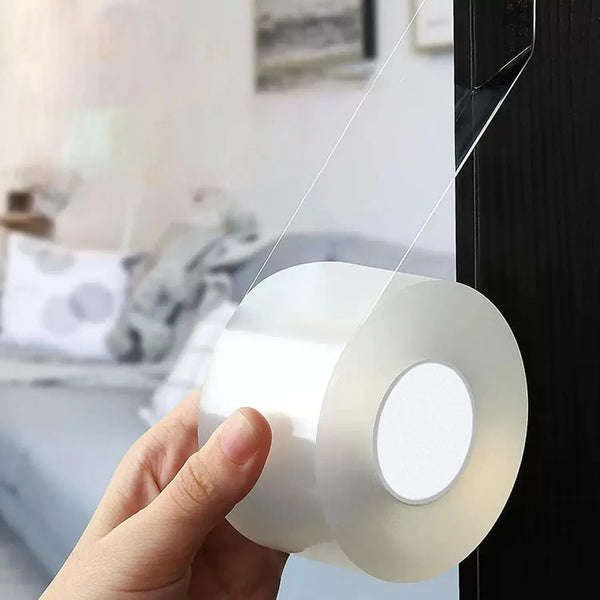 A hand is holding a roll of white weatherproof window sealing tape against a dark surface.