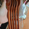 A set of natural wooden spoons and forks packaged in clear plastic.