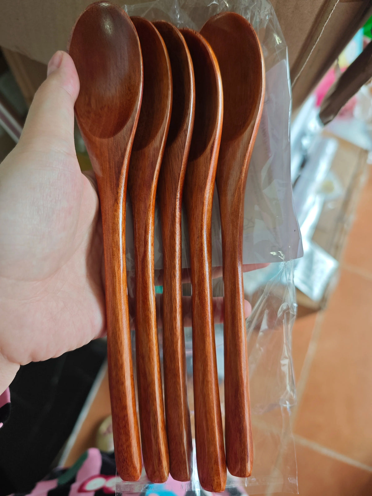 A set of natural wooden spoons and forks packaged in clear plastic.