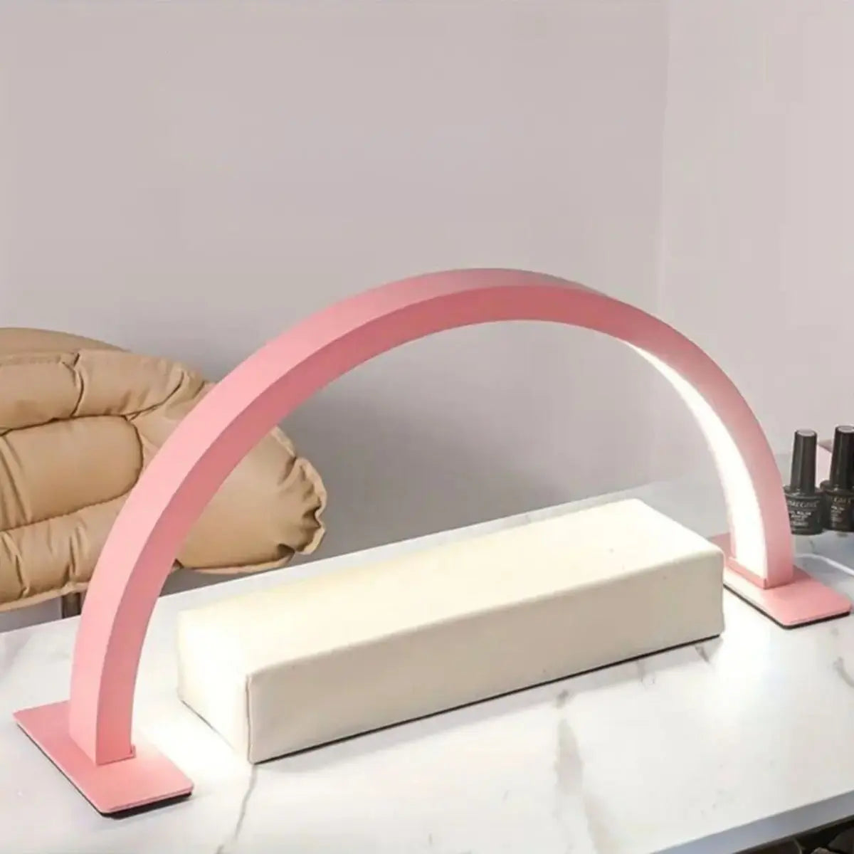Pinkes dimmbares Licht einer Bogenleuchte beleuchtet eine weiße rechteckige Fläche für Nagel- und Wimperndienstleistungen.