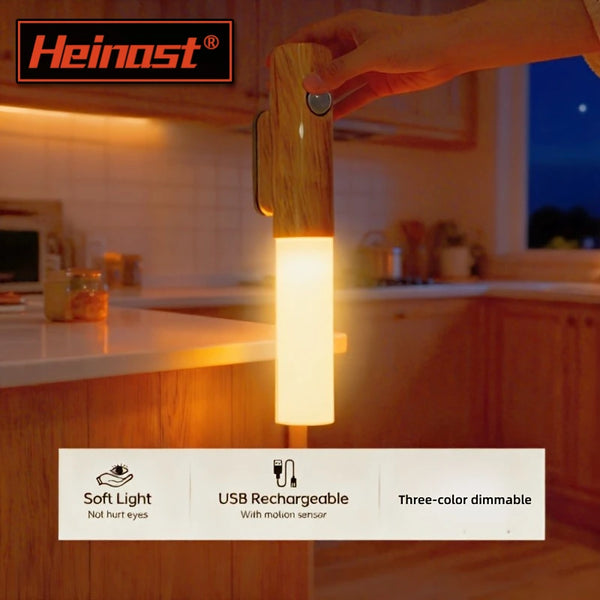 A hand holds a wooden LED night light with a soft glow on a kitchen counter.