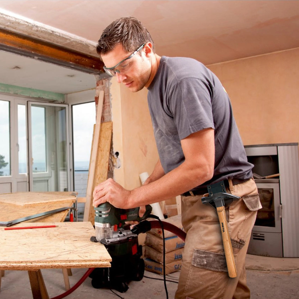 A man wearing glasses is using a power tool on a wooden surface in a construction or workshop setting.