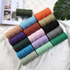 Colección de 100 ovillos de cordón de macramé de algodón natural en varios tonos tierra y vibrantes, dispuestos en diagonal.