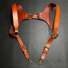 A pair of brown leather men's double shoulder suspenders displayed against a dark background.