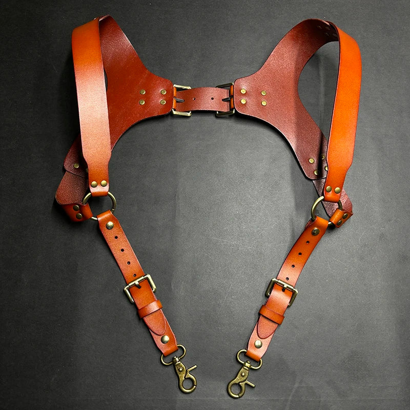 A pair of brown leather men's double shoulder suspenders displayed against a dark background.