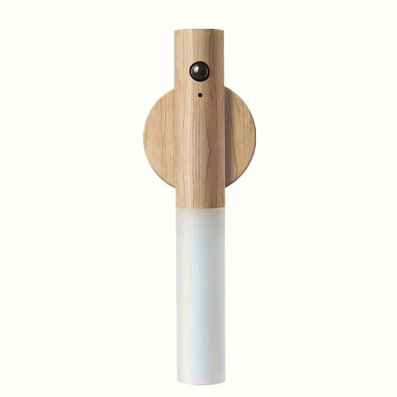 Luz nocturna LED con sensor de movimiento de madera y base cilíndrica blanca.