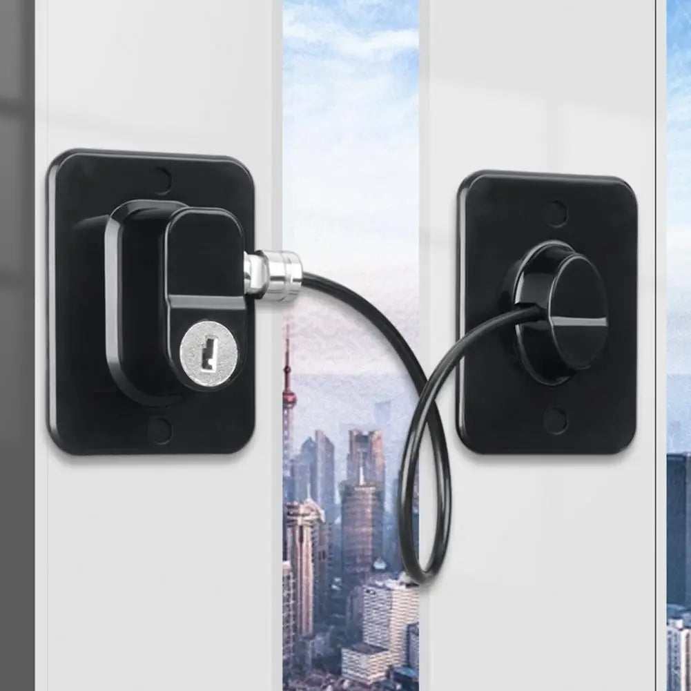 A black universal door and window safety lock installed on a white frame, featuring a cylindrical latch mechanism.