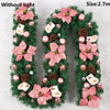Green artificial garland shaped like the letter U decorated with pink flowers and pearl accents