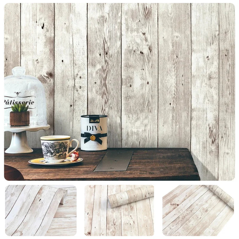 A rustic wooden table with a glass teapot, a tin, and a dark mat set against a light wood plank wall.