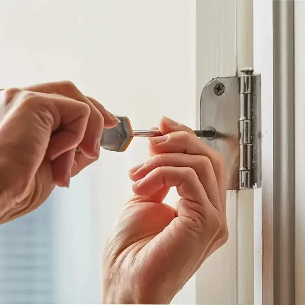 A person's hands are installing a metal latch or hardware piece onto a white window frame.