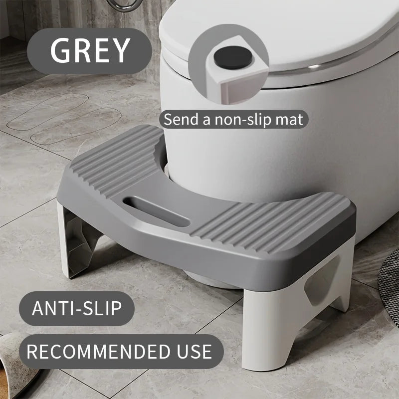 Tabouret de toilette ergonomique gris avec surface antidérapante sur un sol carrelé.
