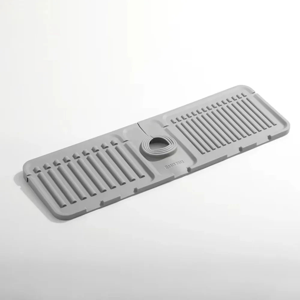 A gray silicone sink drain mat with ribbed texture and a central drain hole.